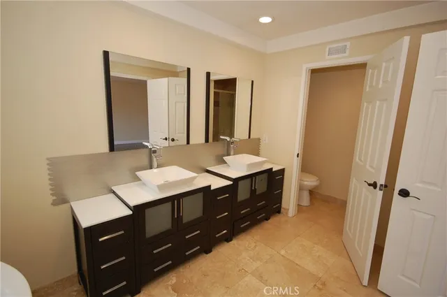 a bathroom with a granite countertop sink and a window