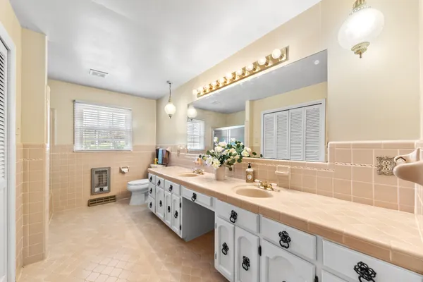 a bedroom with a bed and a large window with wooden floor