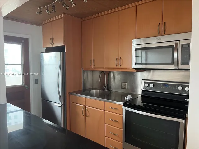 a kitchen with stainless steel appliances granite countertop a refrigerator stove and microwave