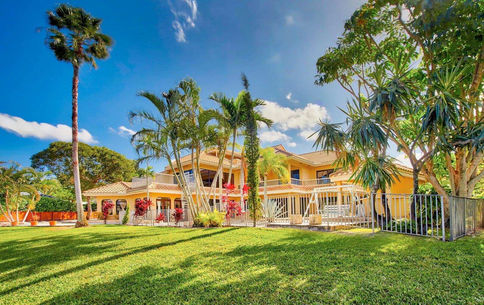 21125 Hamlin Drive Boca Raton, FL 33433 - Photo 37 of 69 a view of a white house with a big yard and palm trees
