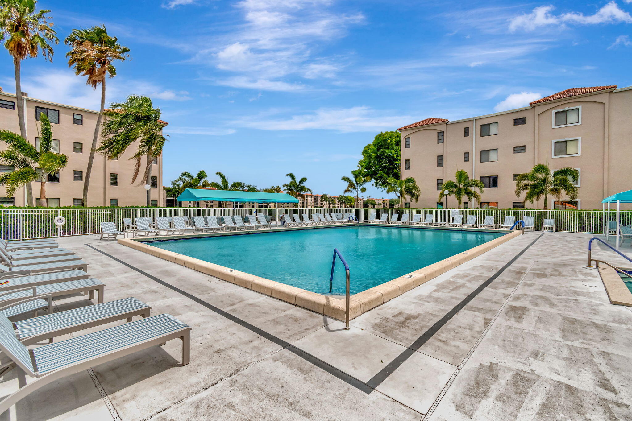 6248 Kings Gate Circle Delray Beach, FL 33484 - Photo 47 of 111 a view of a swimming pool with a lounge chairs