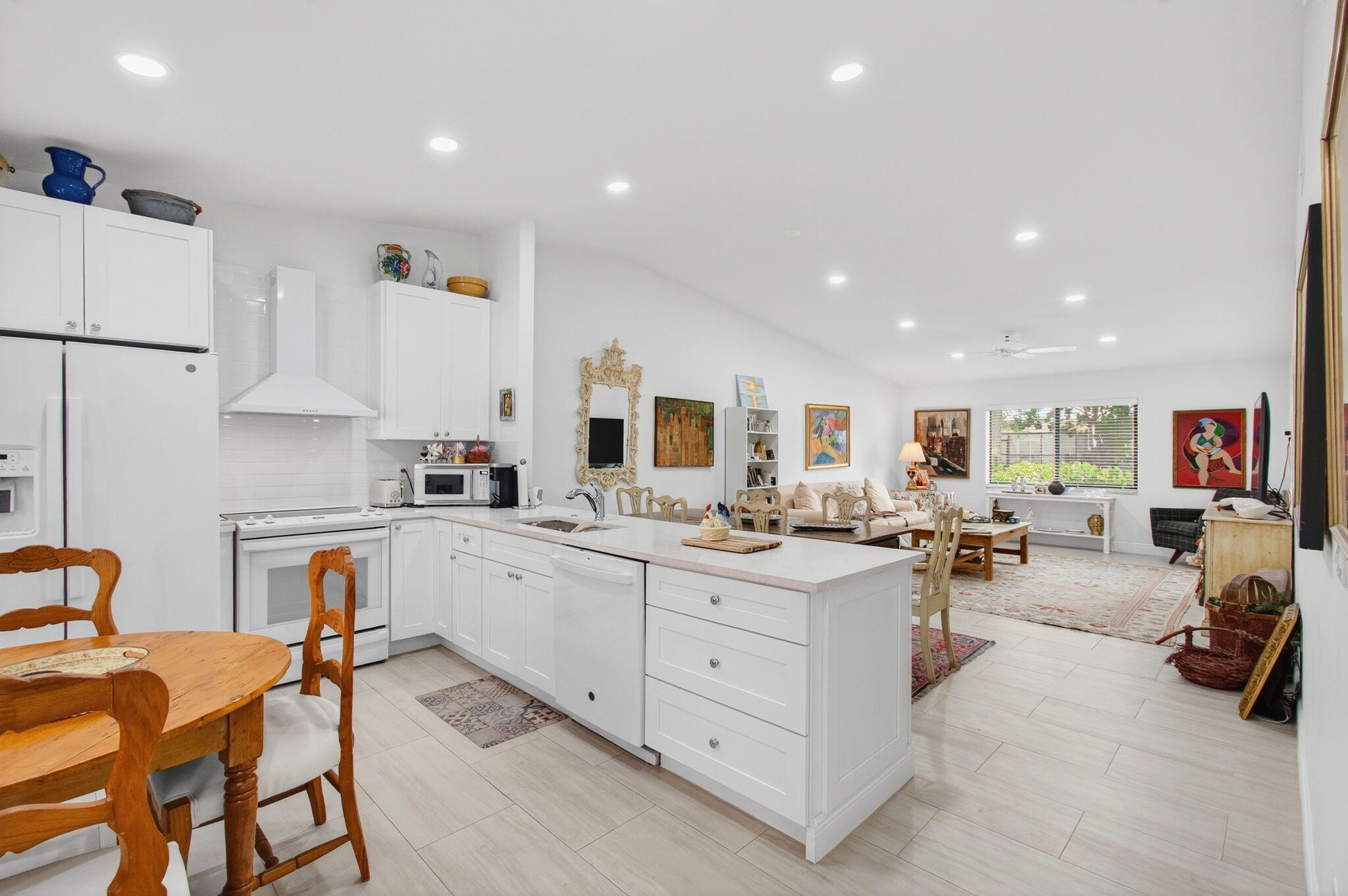 6248 Kings Gate Circle Delray Beach, FL 33484 - Photo 5 of 111 a large white kitchen with furniture a stove a sink a dining table and chairs