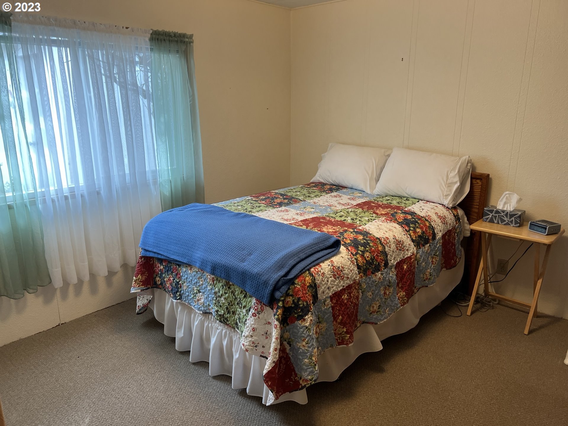 1601 Rhododendron Drive, Unit 586 Florence, OR 97439 - Photo 16 of 22 a bedroom with a bed and a table in it