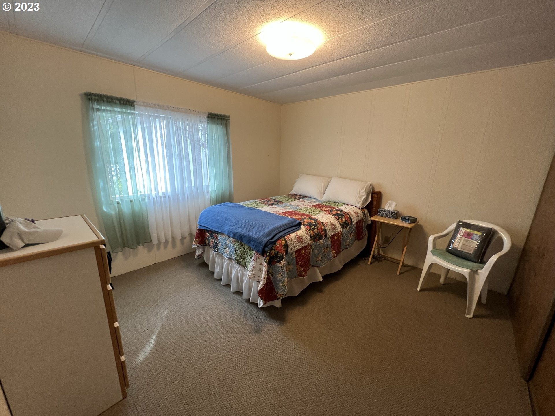 1601 Rhododendron Drive, Unit 586 Florence, OR 97439 - Photo 17 of 22 a bed sitting in a room next to a window