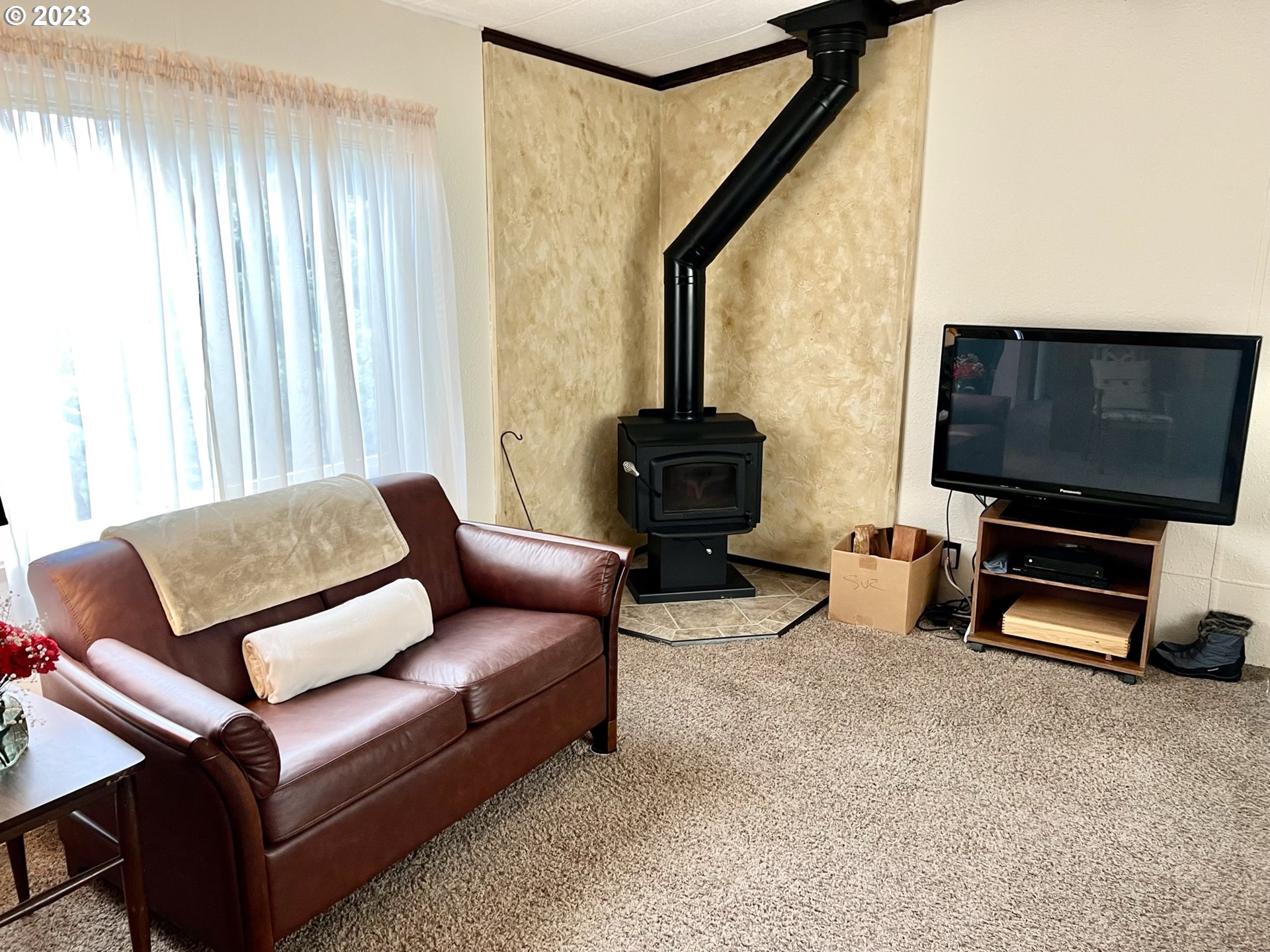 1601 Rhododendron Drive, Unit 586 Florence, OR 97439 - Photo 7 of 22 a living room with furniture and a flat screen tv