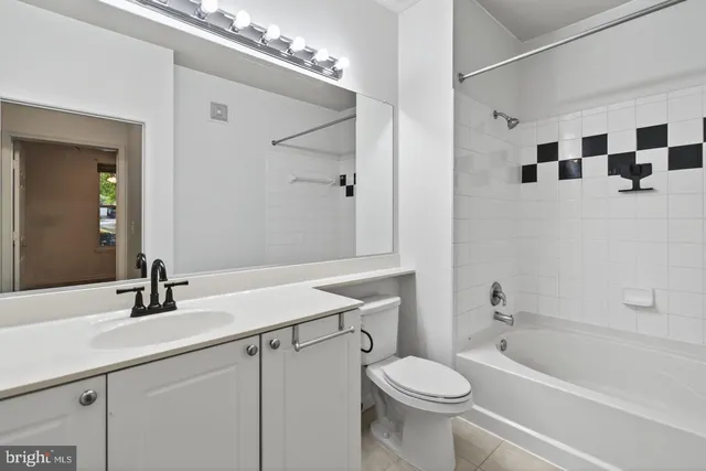 a bathroom with a sink a toilet a mirror and shower