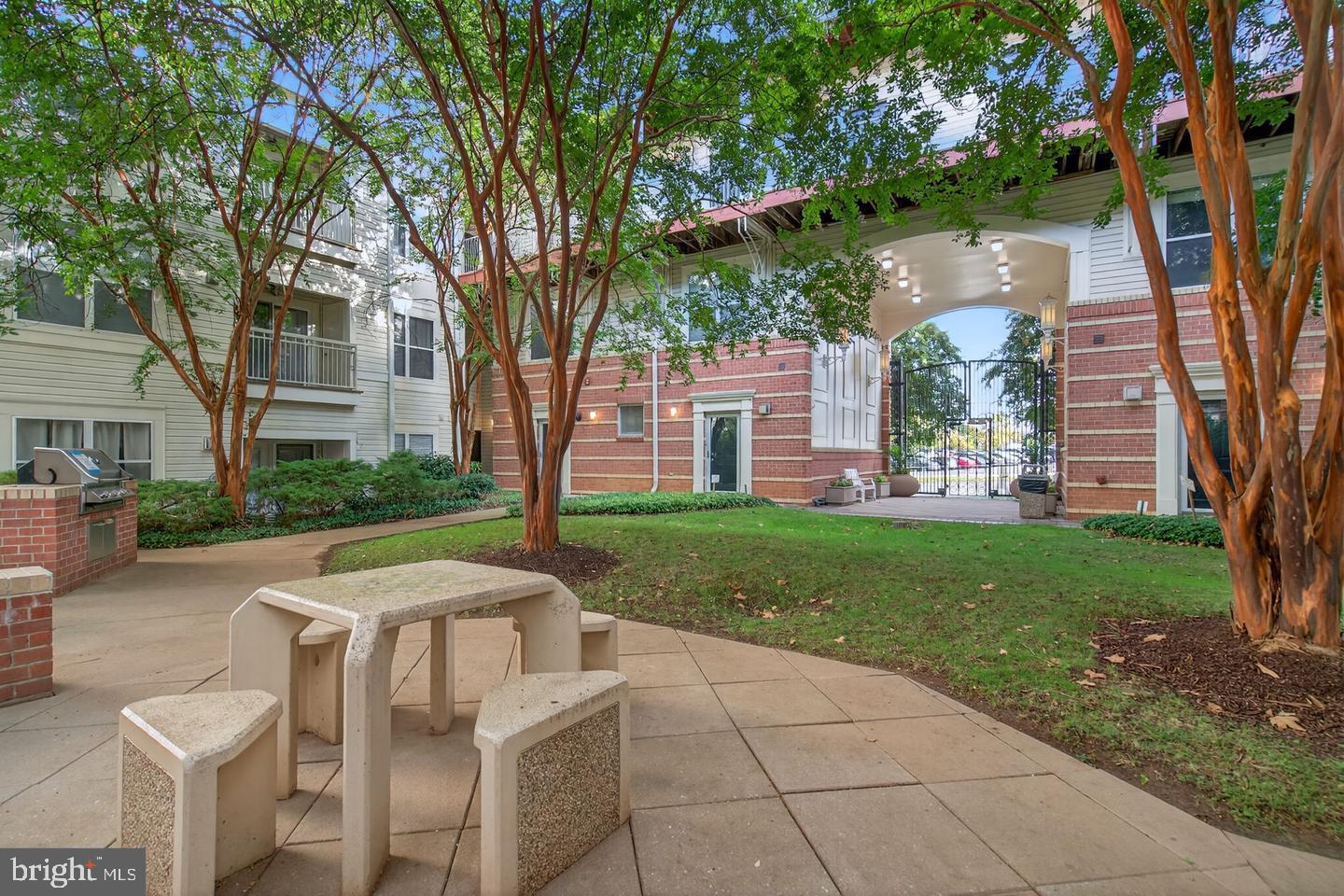 9490 Virginia Center Boulevard, Unit 127 Vienna, VA 22181 - Photo 28 of 31 a view of a backyard with table and chairs and a large tree