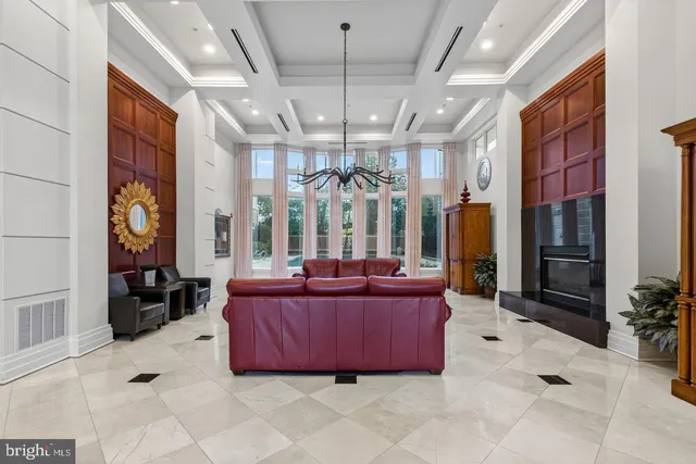 a living room with furniture a chandelier and a large window