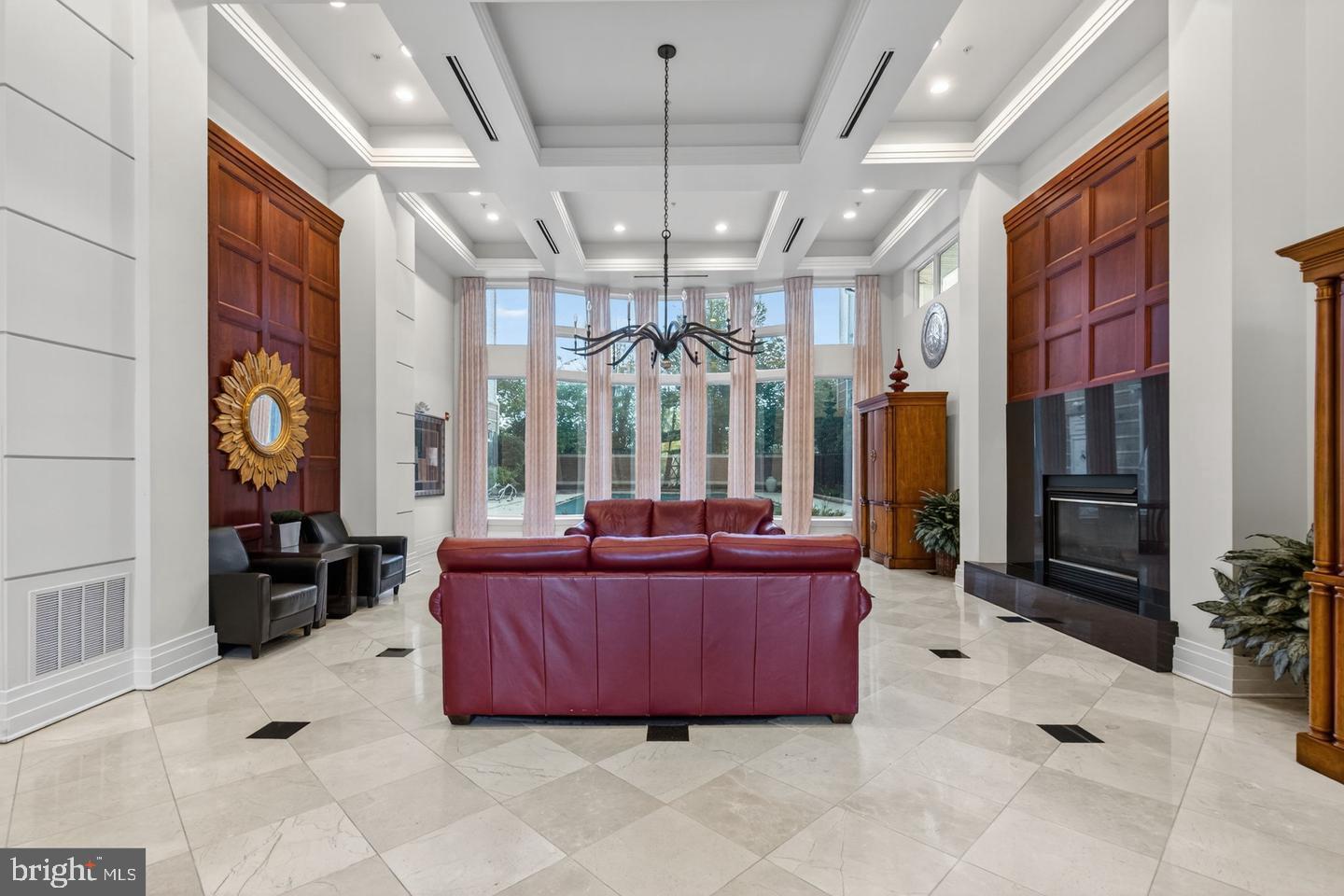 9490 Virginia Center Boulevard, Unit 127 Vienna, VA 22181 - Photo 4 of 31 a living room with furniture a chandelier and a large window