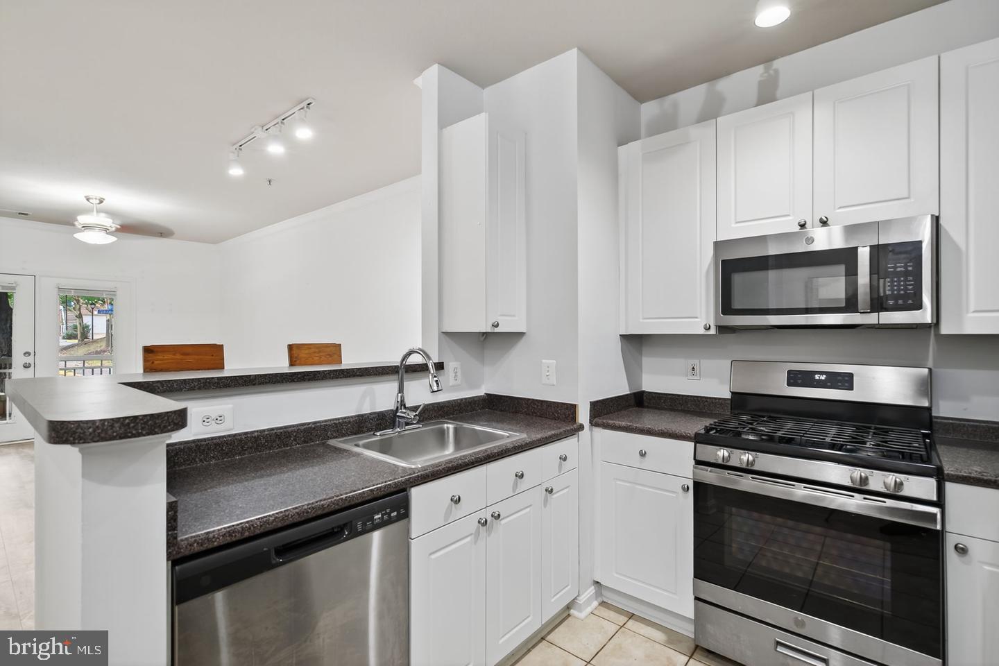 9490 Virginia Center Boulevard, Unit 127 Vienna, VA 22181 - Photo 5 of 31 a kitchen with stainless steel appliances a stove a sink and a microwave