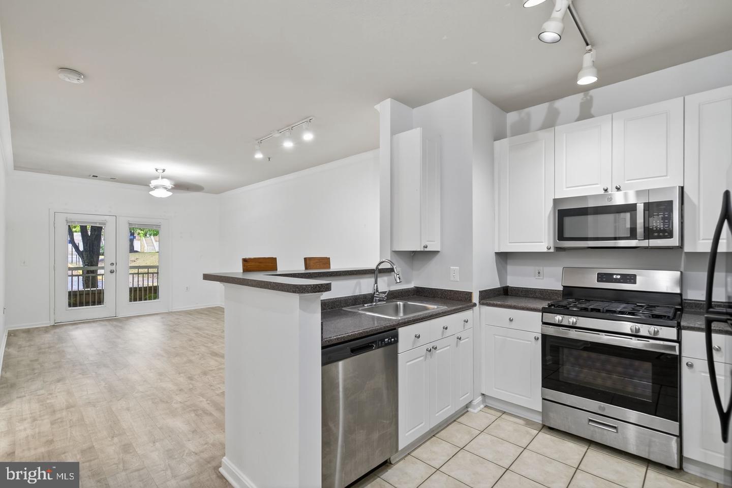 9490 Virginia Center Boulevard, Unit 127 Vienna, VA 22181 - Photo 7 of 31 a kitchen with stainless steel appliances white cabinets and white appliances