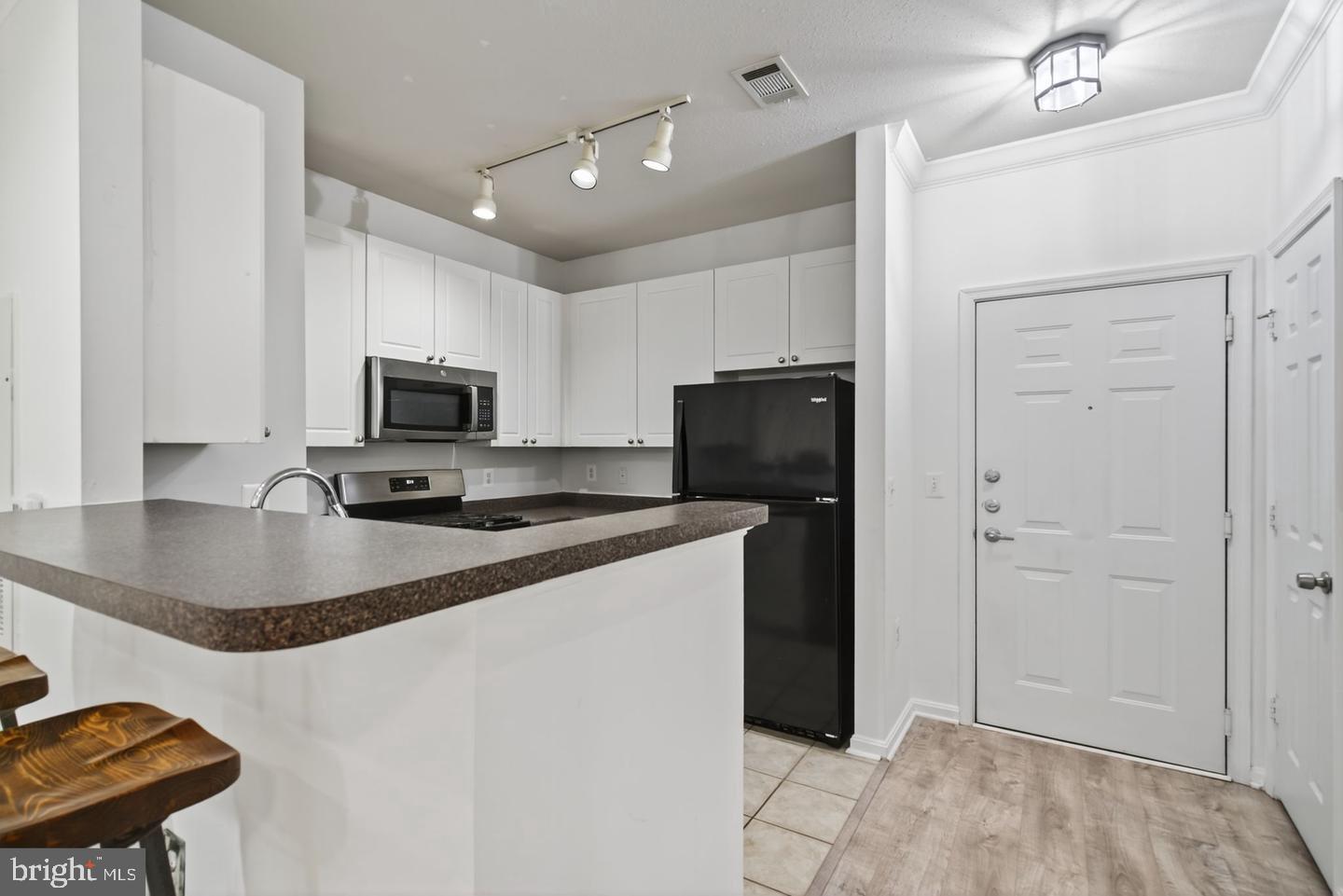 9490 Virginia Center Boulevard, Unit 127 Vienna, VA 22181 - Photo 9 of 31 a kitchen with kitchen island a counter top space appliances and cabinets