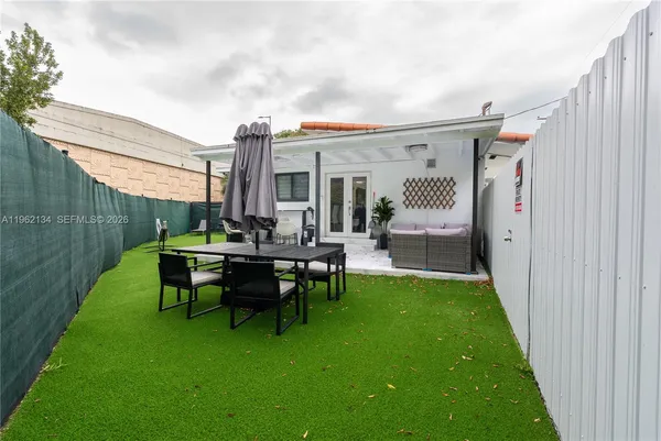 a view of a house with backyard sitting area and garden