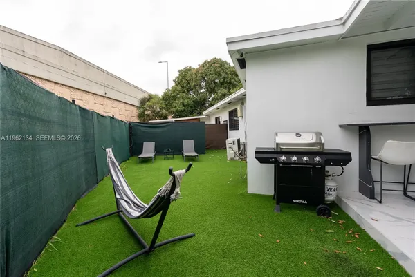 a view of a backyard with chairs potted plants and a table