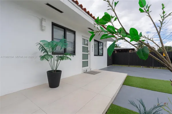 a potted plant sitting in front of a house with potted plants