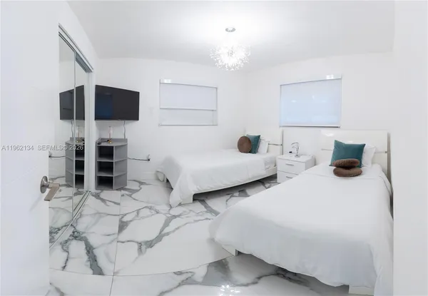 a bedroom with two beds and a flat screen tv