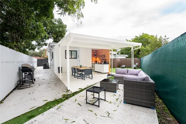 a backyard of a house with barbeque oven table and chairs