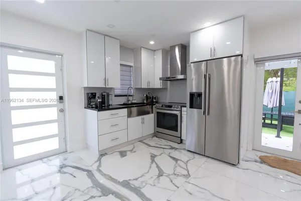 a kitchen with a refrigerator sink and cabinets