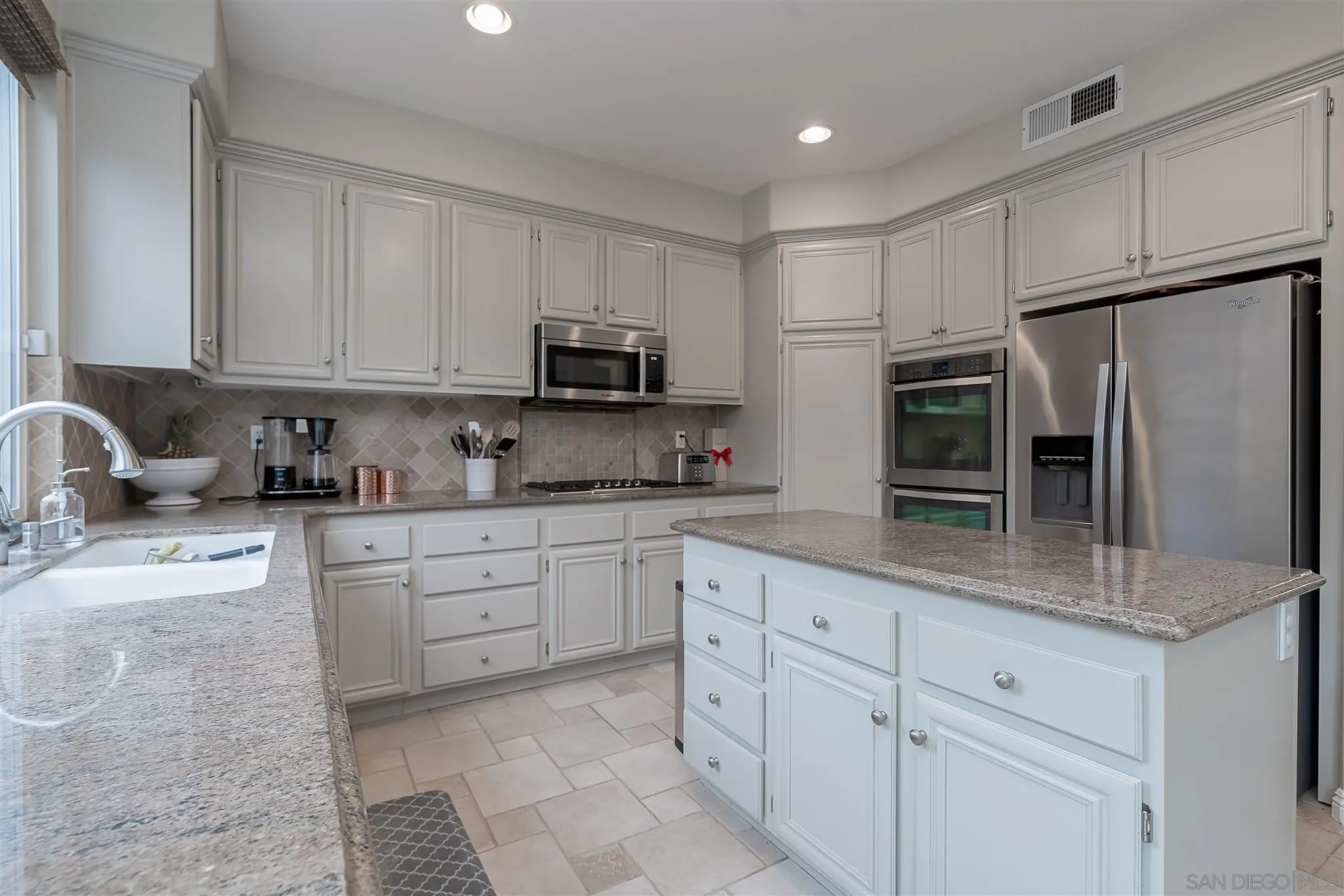 6716 Tea Tree Street Carlsbad, CA 92011 - Photo 12 of 39 a kitchen with cabinets stainless steel appliances and a counter space