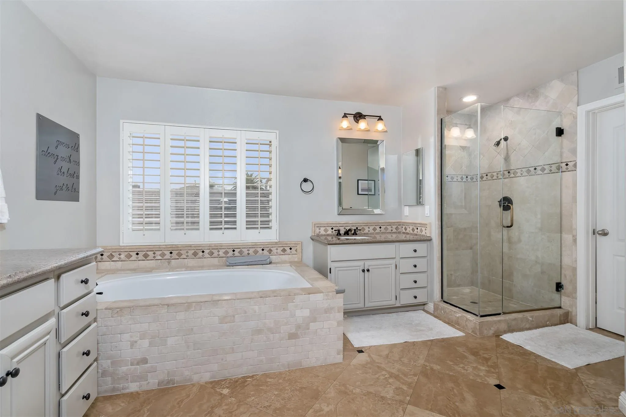 6716 Tea Tree Street Carlsbad, CA 92011 - Photo 29 of 39 a spacious bathroom with a granite countertop sink a mirror a bathtub and shower