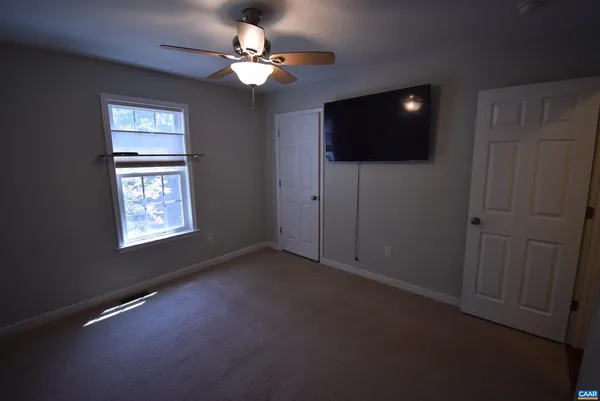 a view of a livingroom with an empty space flat screen tv and outdoor view