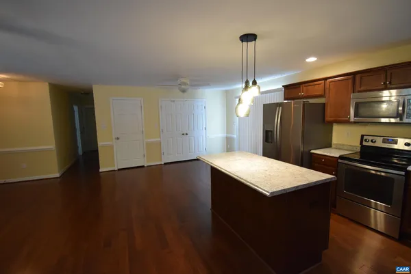 a kitchen with stainless steel appliances granite countertop a refrigerator a sink and a stove