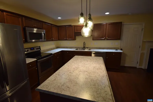 a kitchen with a sink a counter space appliances and cabinets