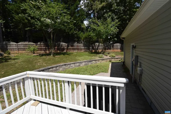a view of a wooden deck and a yard with trees