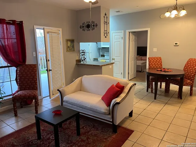 a living room with furniture a dining table and a chandelier