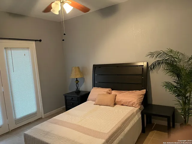 a bedroom with a bed and a potted plant