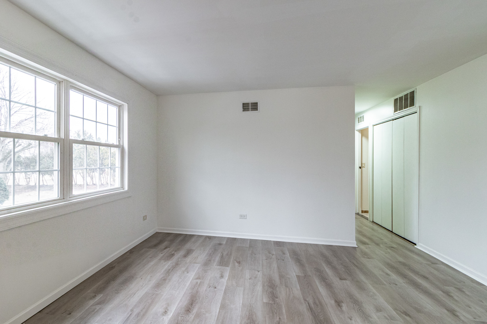 1324 Alpine Court, Unit 1324 Wheeling, IL 60090 - Photo 3 of 12 an empty room with wooden floor and windows