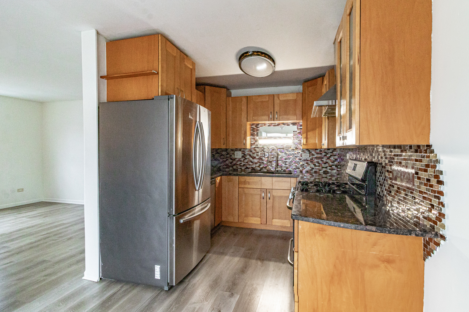 1324 Alpine Court, Unit 1324 Wheeling, IL 60090 - Photo 6 of 12 a kitchen with granite countertop a refrigerator and a sink
