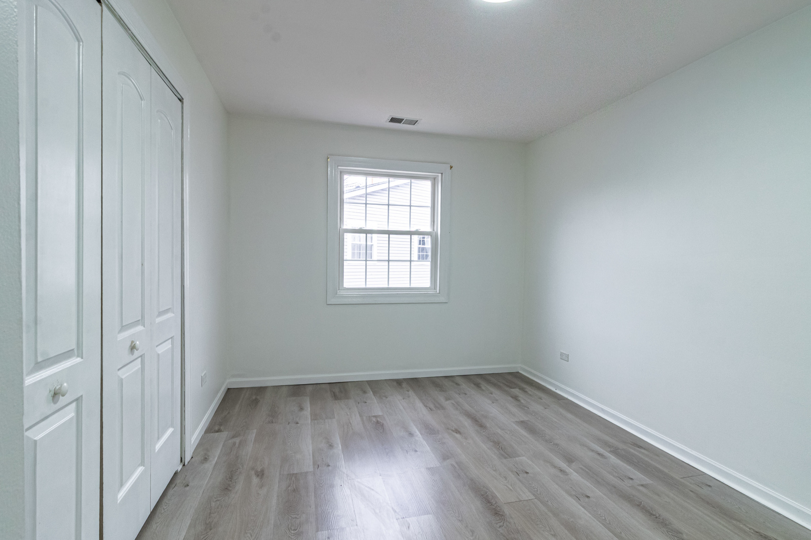 1324 Alpine Court, Unit 1324 Wheeling, IL 60090 - Photo 9 of 12 wooden floor in an empty room with a window