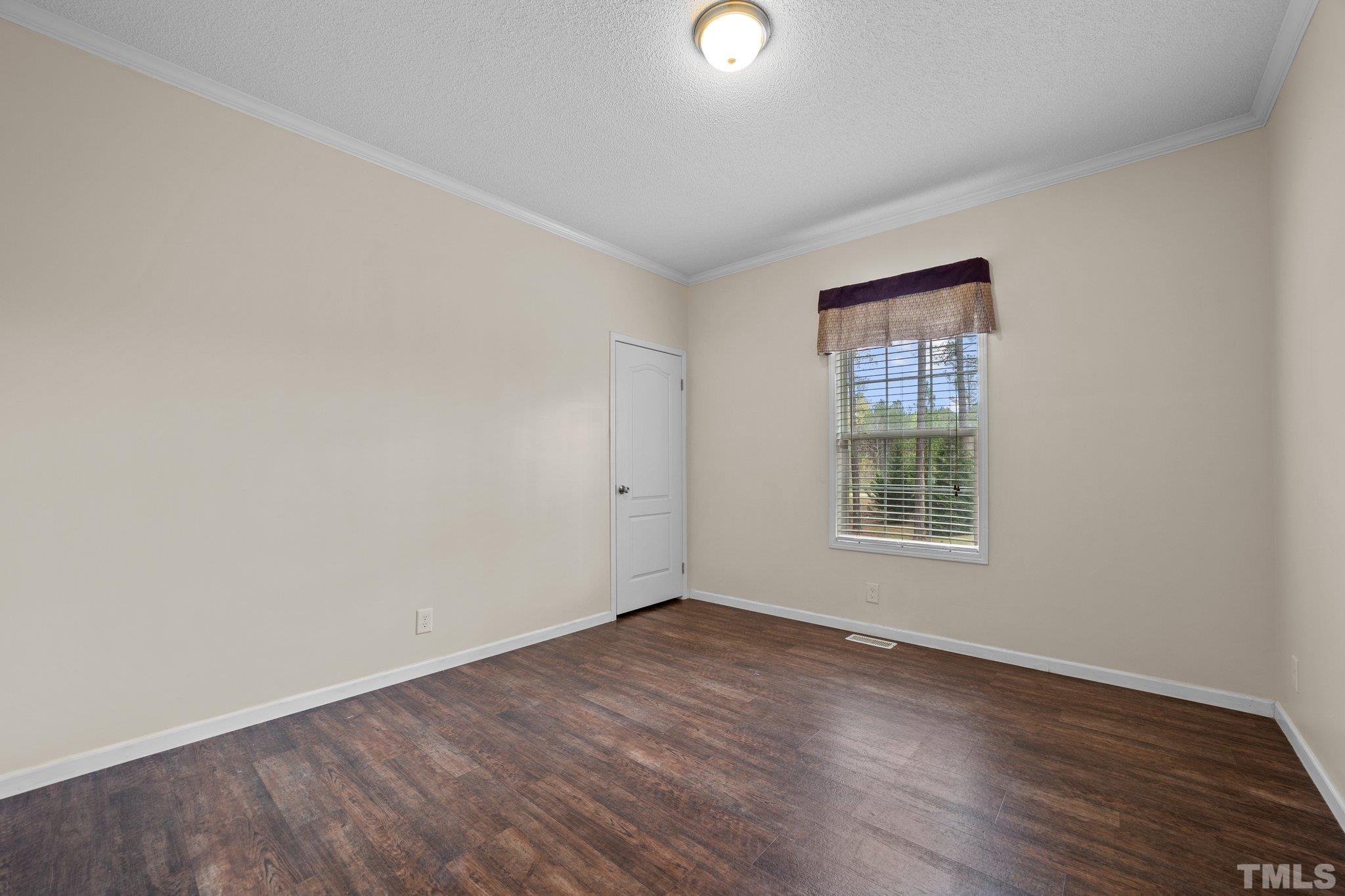 11242 Bissette Road Middlesex, NC 27557 - Photo 15 of 24 an empty room with wooden floor and windows