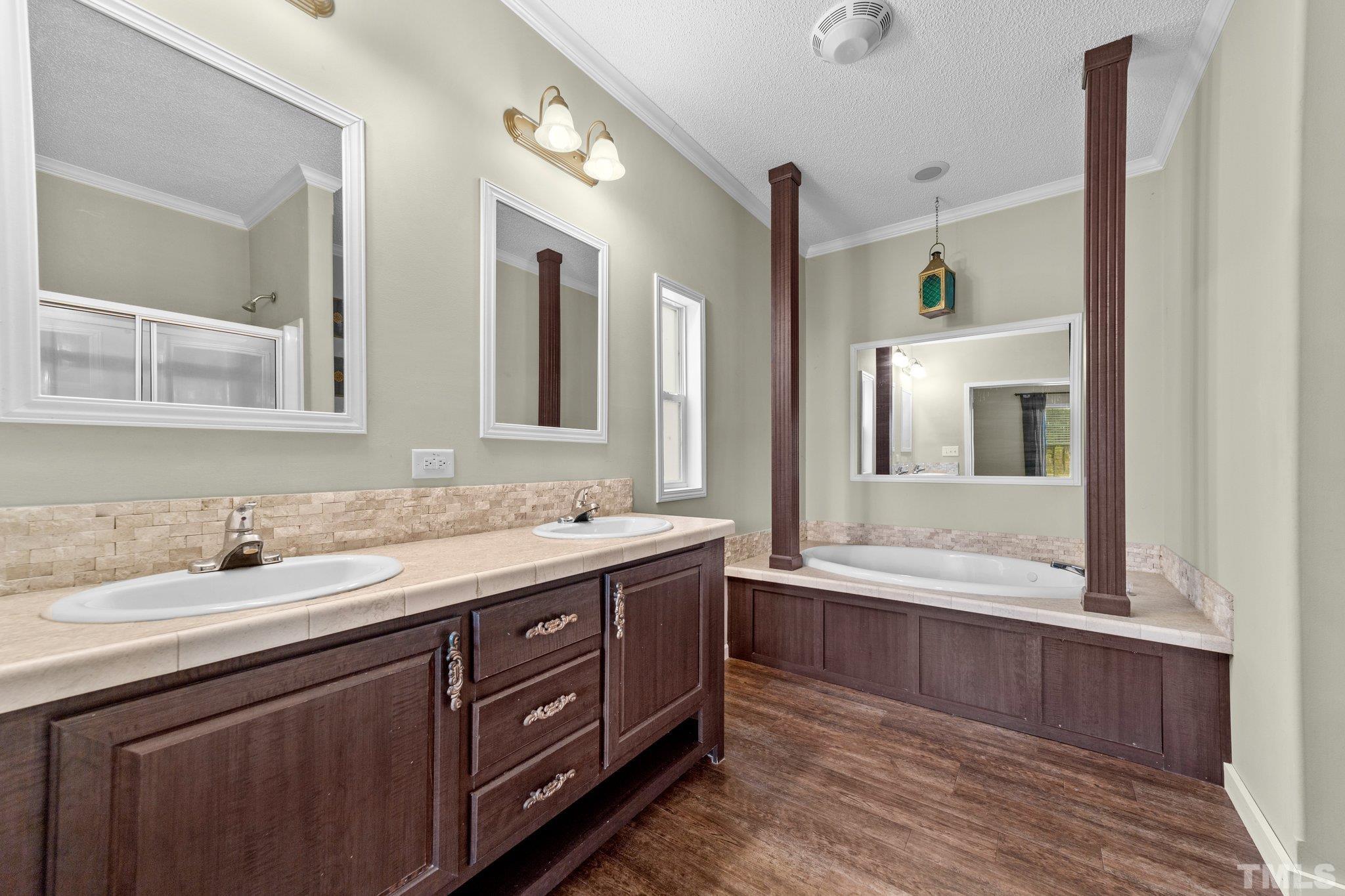 11242 Bissette Road Middlesex, NC 27557 - Photo 20 of 24 a bathroom with a sink double vanity granite tub shower and a mirror