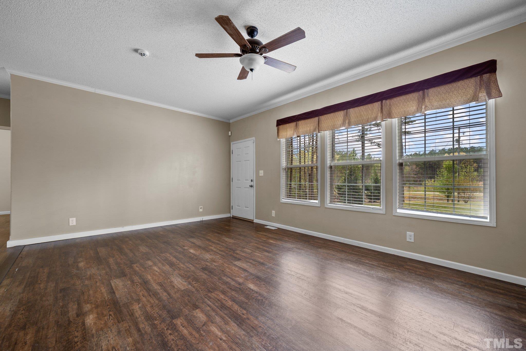 11242 Bissette Road Middlesex, NC 27557 - Photo 8 of 24 a view of an empty room with a window and wooden floor