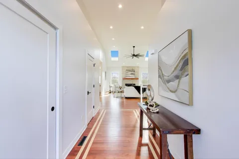 a view of a hallway with wooden floor and staircase