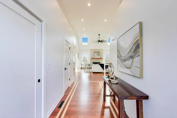 a view of a hallway with wooden floor and staircase