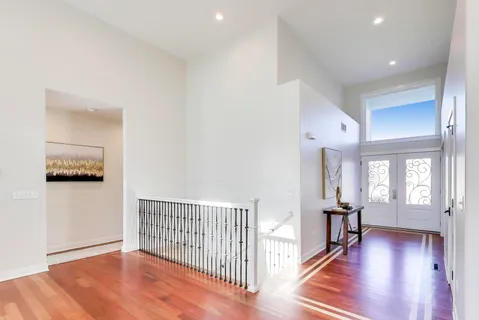 a view of a hallway with wooden floor and windows