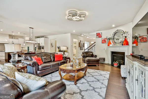 a view of a dining room and livingroom with furniture wooden floor a chandelier