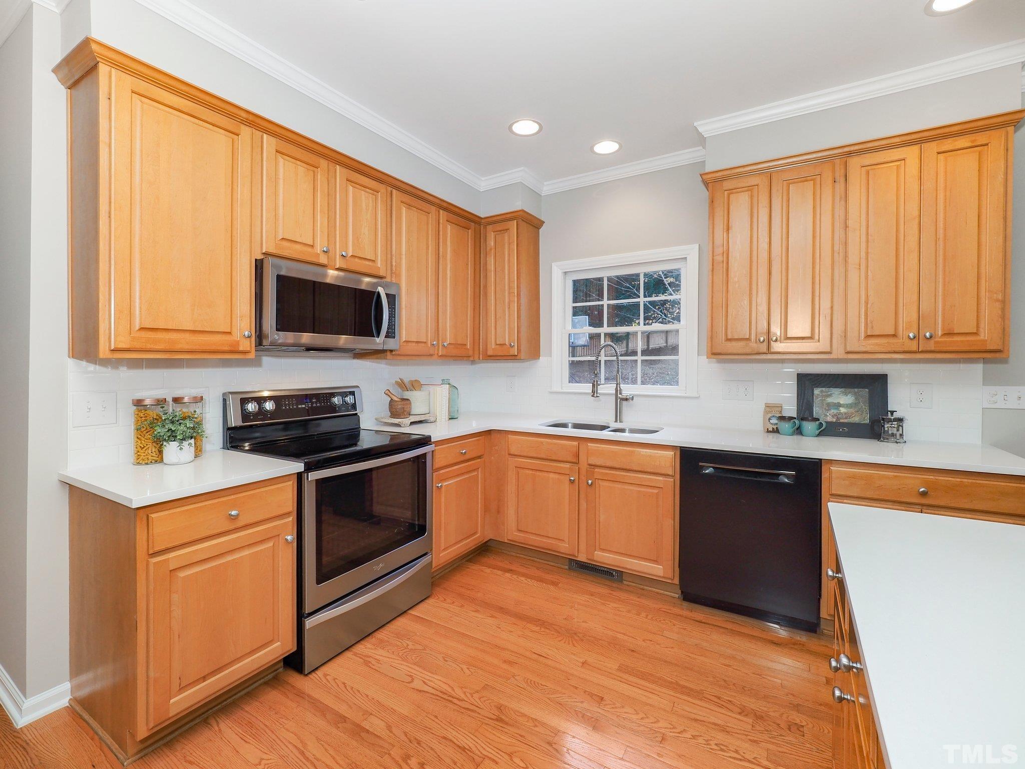 703 Haddon Hall Drive Apex, NC 27502 - Photo 15 of 49 a kitchen with stainless steel appliances granite countertop wooden cabinets a stove a sink and a microwave