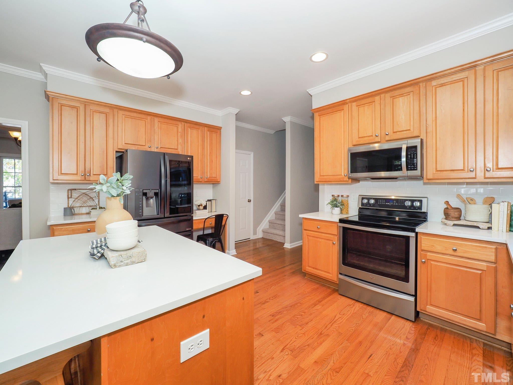 703 Haddon Hall Drive Apex, NC 27502 - Photo 18 of 49 a kitchen with stainless steel appliances a stove sink microwave and refrigerator