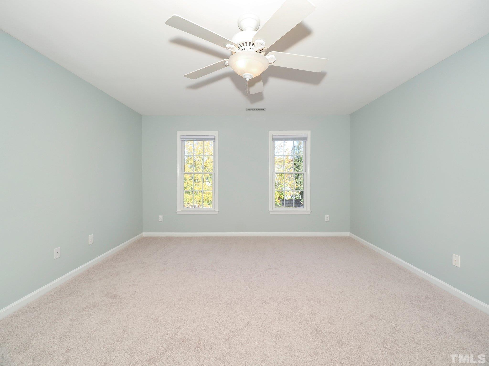 703 Haddon Hall Drive Apex, NC 27502 - Photo 25 of 49 an empty room with windows and ceiling fan