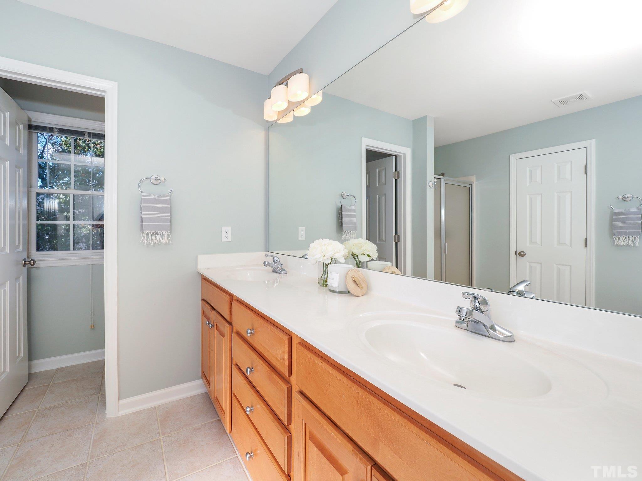 703 Haddon Hall Drive Apex, NC 27502 - Photo 27 of 49 a bathroom with a granite countertop sink and a mirror