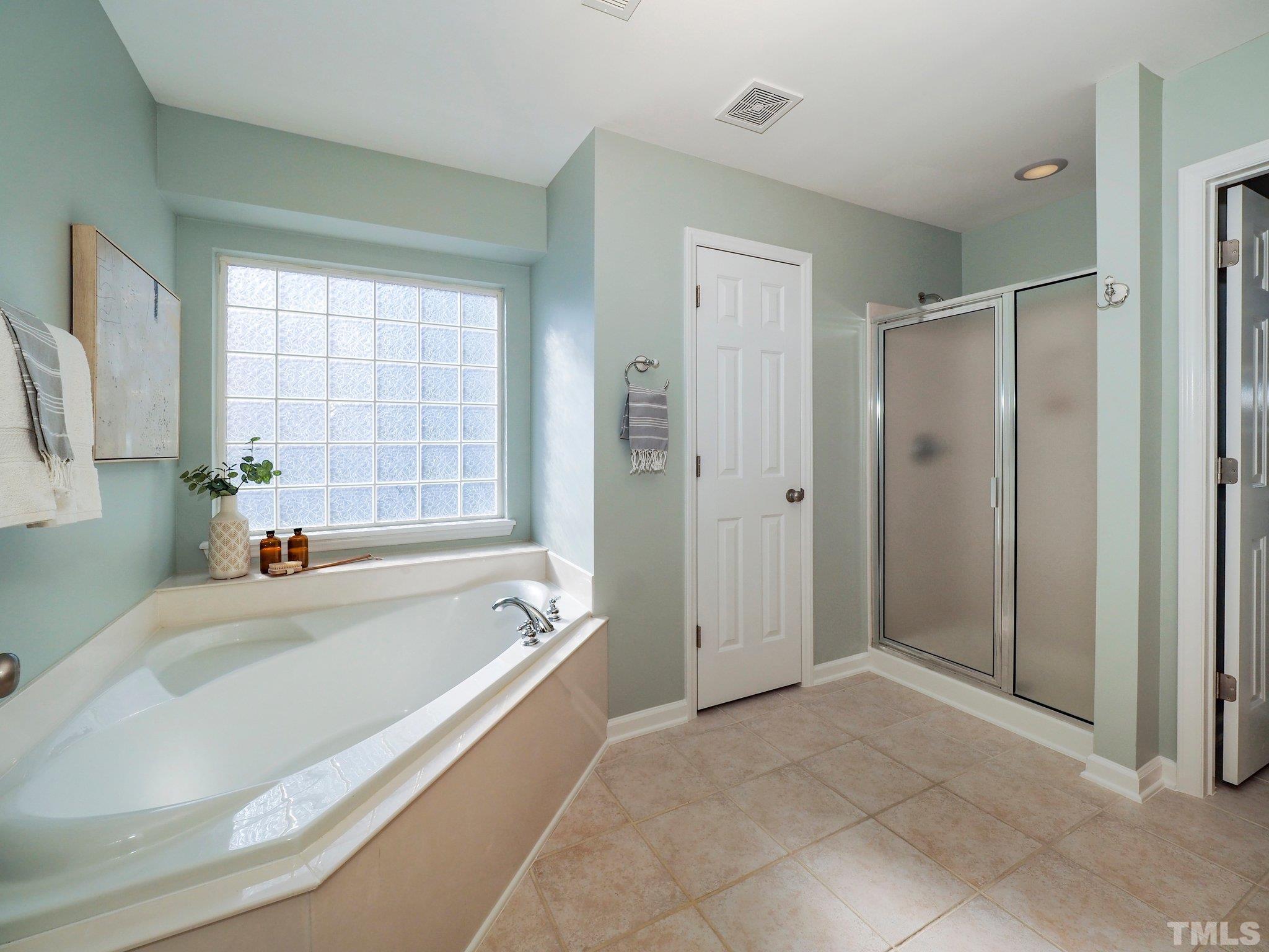 703 Haddon Hall Drive Apex, NC 27502 - Photo 28 of 49 a spacious bathroom with a tub shower and windows
