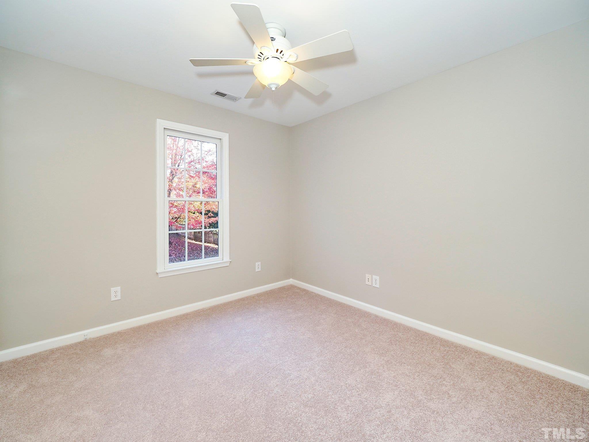 703 Haddon Hall Drive Apex, NC 27502 - Photo 31 of 49 an empty room with a window and a ceiling fan