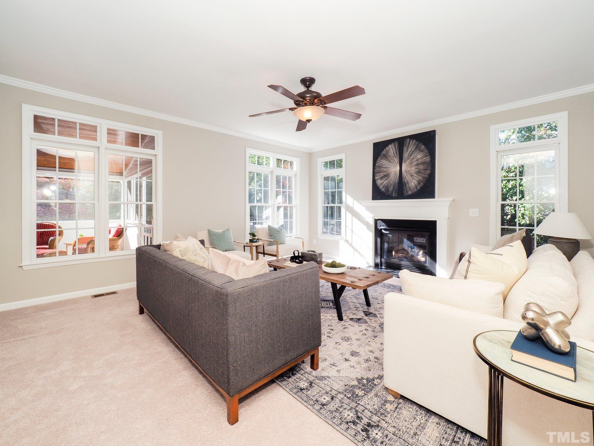 703 Haddon Hall Drive Apex, NC 27502 - Photo 10 of 49 a living room with furniture a fireplace and a large window