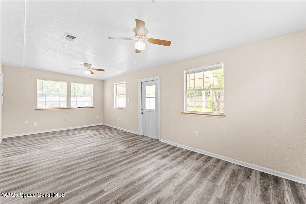 5510 Holden Road Cocoa, FL 32927 - Photo 17 of 51 a view of an empty room with wooden floor and a window