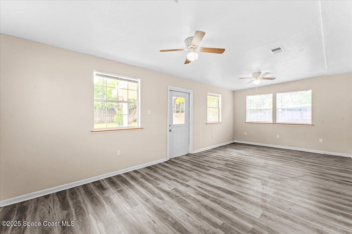 5510 Holden Road Cocoa, FL 32927 - Photo 19 of 51 a view of an empty room with a window and wooden floor
