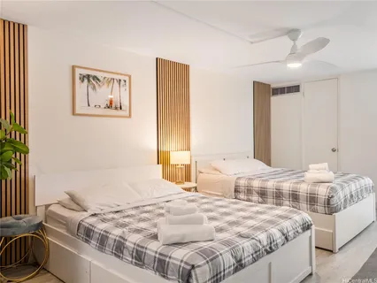 a bedroom with two beds and a large mirror